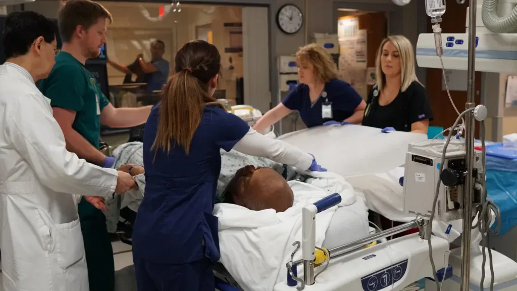 Group of medical workers and a man in a hospital bed