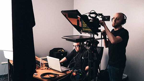 Man operating camera and teleprompter